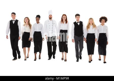 Portrait Of Happy Restaurant Staff Walking Against White Background Stock Photo