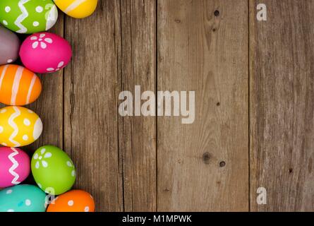 Colorful Easter egg side border against a rustic wood background Stock Photo