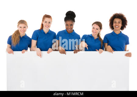 Group Of Smiling Female Janitors Holding Billboard In Front Of White Background Stock Photo