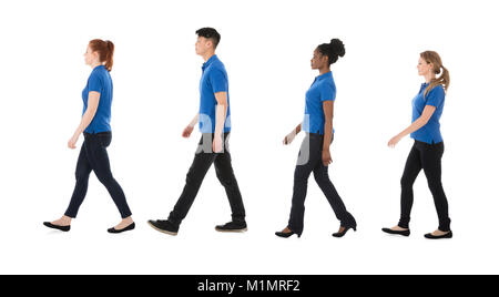 Multiracial Janitors Walking In Row Against White Background Stock Photo