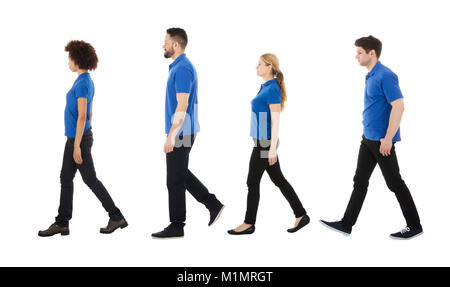 Multiracial Janitors Walking In Row Against White Background Stock Photo