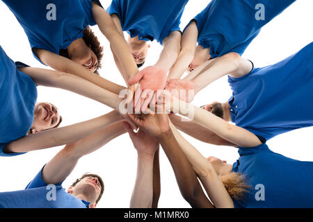 Low Angle View Of Smiling Multiracial Janitors Stacking Hands Stock Photo