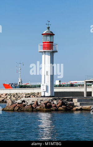 White lighthouse tower with red top stands on the entrance breakwater in port of Burgas, Black Sea coast, Bulgaria Stock Photo
