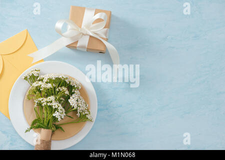 Tet Holiday Concept. Gold Envelope (Lucky money) on table with Table setting with Plate and Flowers. Stock Photo