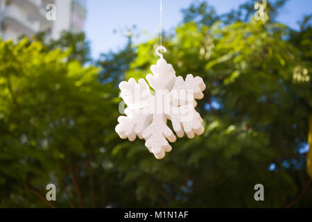 foam plastic like snow on green tree blur background Stock Photo