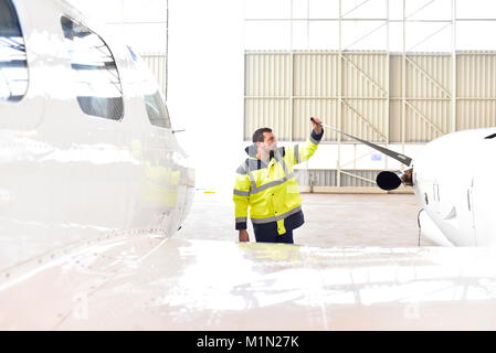 Airport workers check an aircraft for safety in a hangar Stock Photo