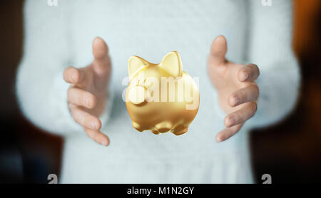 Golden piggy bank on hand, saving money Stock Photo