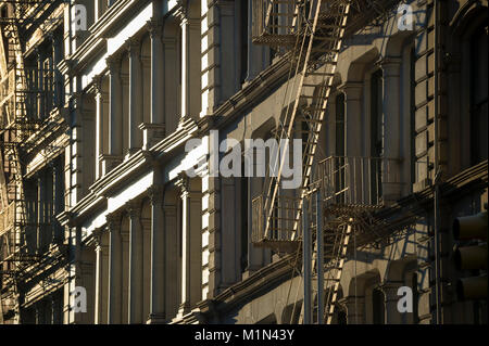 Close-up of fire escapes running down the facades of iconic cast iron buildings in Soho, New York City Stock Photo