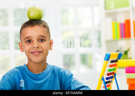 child playing with apple on worktable Stock Photo