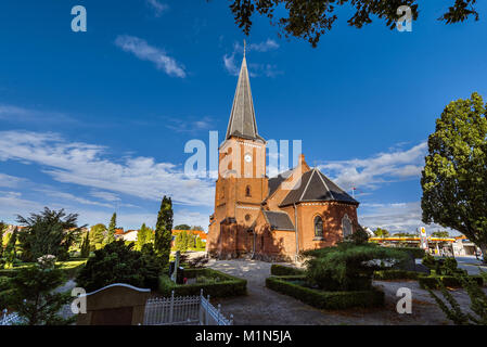 Old city cemetary and catholic church in Dragor, Denmark - September, 21th, 2015. Gravestones, greenery and cloud sky at the early morning in fishman  Stock Photo