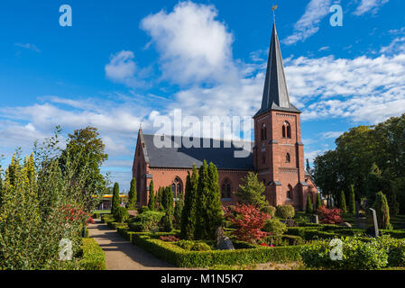 Old city cemetary and catholic church in Dragor, Denmark - September, 21th, 2015. Gravestones, greenery and cloud sky at the early morning in fishman  Stock Photo