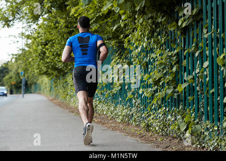 Back view of young male athlete running in the street Stock Photo