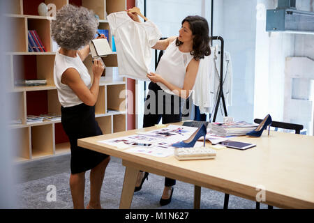 Two women discussing clothes in a creative media office Stock Photo