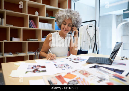 Senior female media creative working on the phone Stock Photo