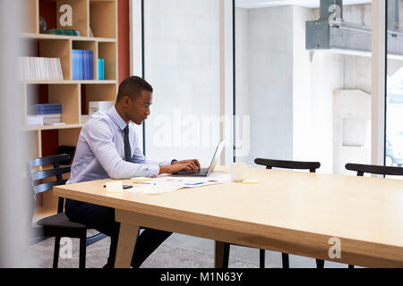 Young black businessman working alone in an office Stock Photo