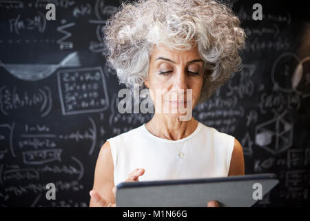 Middle aged academic woman using tablet, close up Stock Photo
