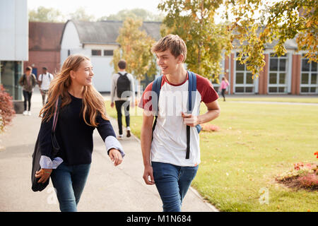 Teenage Students Walking Around College Campus Together Stock Photo