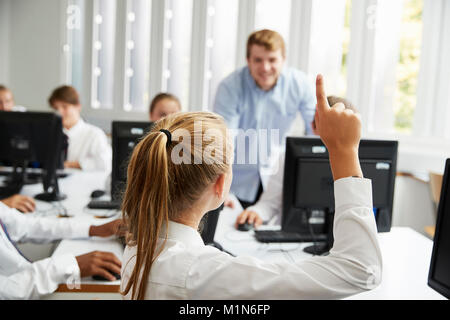 Teenage Students Asking Teacher Question In IT Class Stock Photo