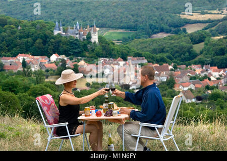 France. Burgundy. La Rochepot near Beaune. Wine region. Couple having picnic with Castle and village of La Rochepot in background. Stock Photo