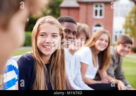 Group Of Teenage Students Sitting Outside School Buildings Stock Photo