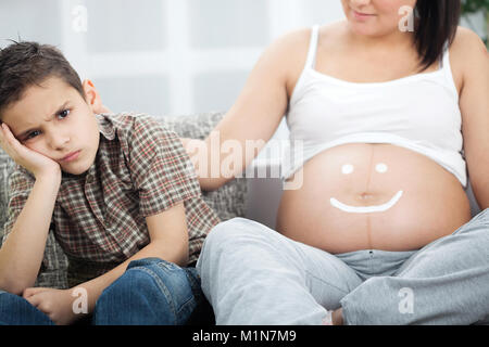 little boy is not happy to have a brother Stock Photo