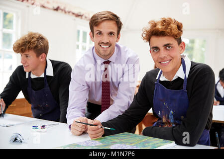 Portrait Of Male Teacher Helping Teenage Pupils In Art Class Stock Photo