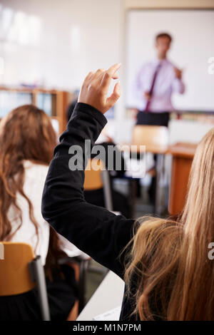 Female Student Raising Hand To Ask Question In Classroom Stock Photo