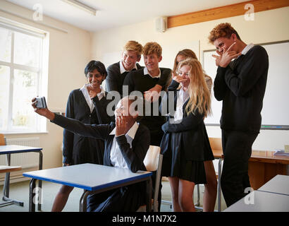 Group Of Teenage Students Posing For Selfie In Classroom Stock Photo