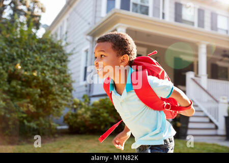 Young Boy Leaving House To Walk To School Stock Photo
