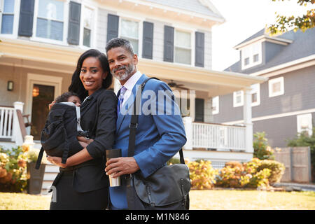 Portrait Of Business Couple With Baby Son Leaving House For Work Stock Photo