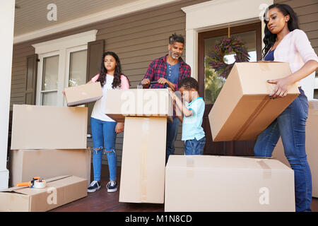 Children Helping Children With Boxes On Moving In Day Stock Photo