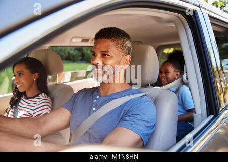 Family In Car Going On Road Trip Stock Photo