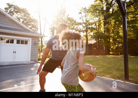 Father And Son Playing Basketball On Driveway At Home Stock Photo