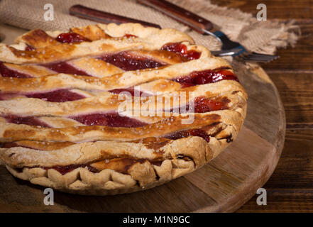 Whole cherry pie on a wooden platter Stock Photo