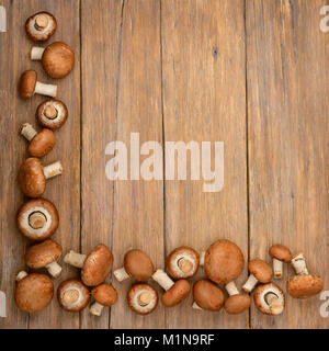 Top view of champignons on a wooden kitchen table. Stock Photo