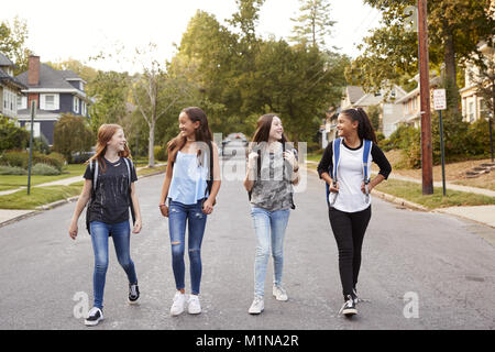 Four young teen girls walking in the road, full length Stock Photo