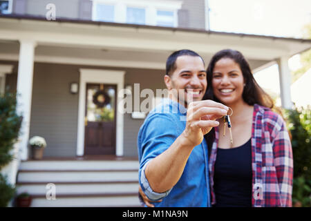 Portrait Of Couple Holding Keys To New Home On Moving In Day Stock Photo