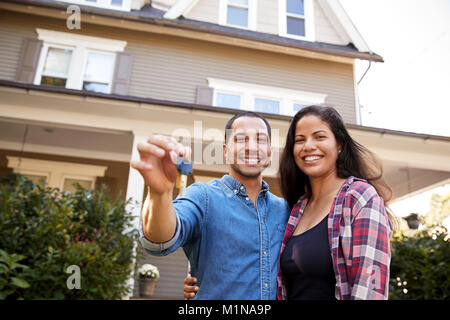 Portrait Of Couple Holding Keys To New Home On Moving In Day Stock Photo