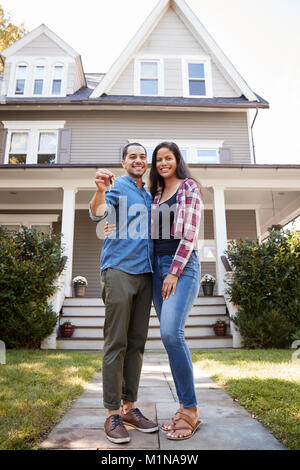 Portrait Of Couple Holding Keys To New Home On Moving In Day Stock Photo