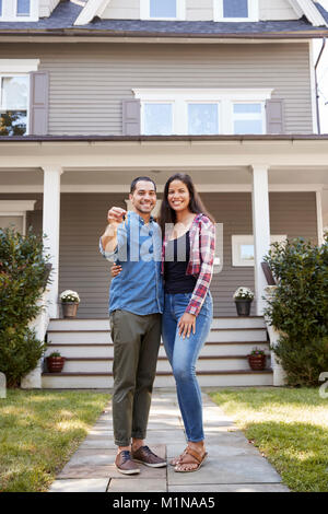 Portrait Of Couple Holding Keys To New Home On Moving In Day Stock Photo