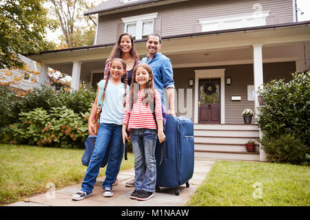 Portrait Of Family With Luggage Leaving House For Vacation Stock Photo
