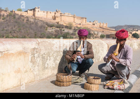 Jaipur, India – March 17 2017: Snake charmers sitting and playing music for demonstration of the cobra dance outside famous Amer fort in Jaipur, India Stock Photo