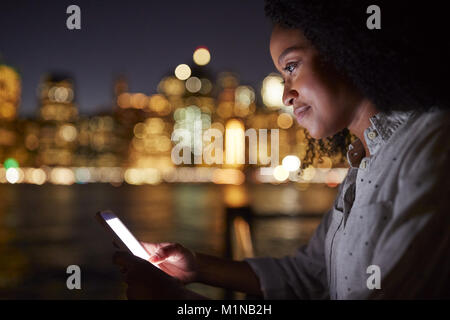 Woman use of mobile phone in city at night Stock Photo - Alamy