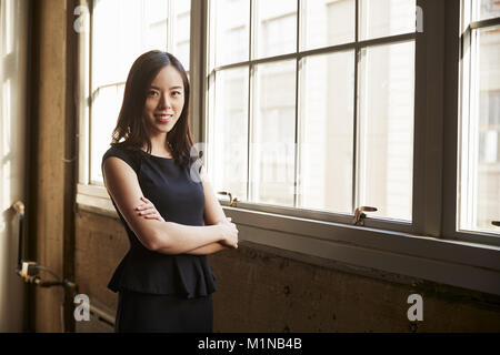 Smiling young Chinese business woman turning to camera Stock Photo