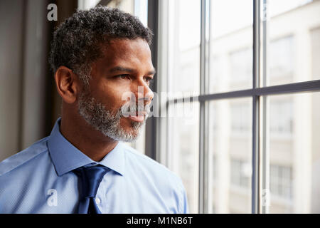 Middle aged black businessman looking out of window Stock Photo