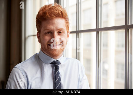 Young red haired bearded businessman smiling to camera Stock Photo