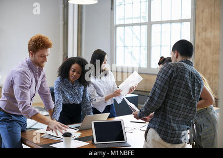 Young creatives discussing brainstorm ideas around a table Stock Photo