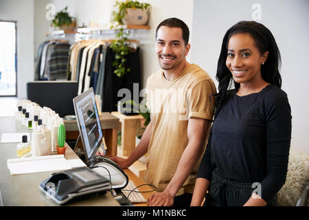 Smiling colleagues behind the counter in clothing store Stock Photo