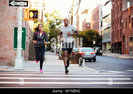 Young black couple jogging in Brooklyn street Stock Photo