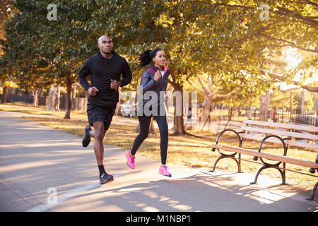 Young black couple jogging in a Brooklyn park Stock Photo
